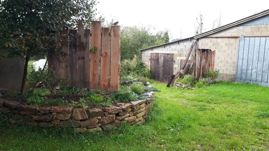 Muret en pierre sèche et palissade bois brûlé